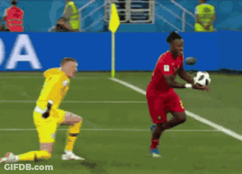 A Soccer Player In Red Runs Towards A Goal While A Goalie In Yellow Watches GIF