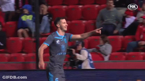 A Soccer Player Is Celebrating A Goal In Front Of A Crowd Of People . GIF