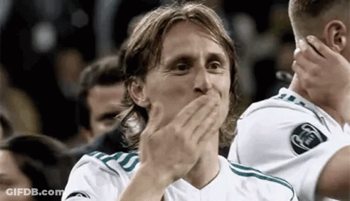 A Soccer Player Is Covering His Mouth With His Hands While Another Player Applauds . GIF
