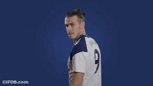 A Soccer Player Is Flexing His Muscles While Wearing A White Jersey With A Number 9 On It . GIF