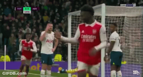 A Soccer Player Is Giving A High Five To Another Player On The Field . GIF