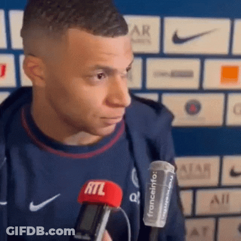A Soccer Player Is Holding A Microphone In His Hand And Talking Into It . GIF