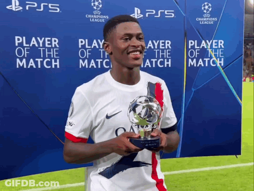 A Soccer Player Is Holding A Trophy In Front Of A Ps5 Sign GIF