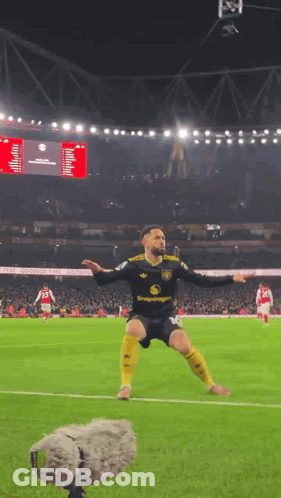 A Soccer Player Is Jumping In The Air On A Field With A Microphone Behind Him GIF