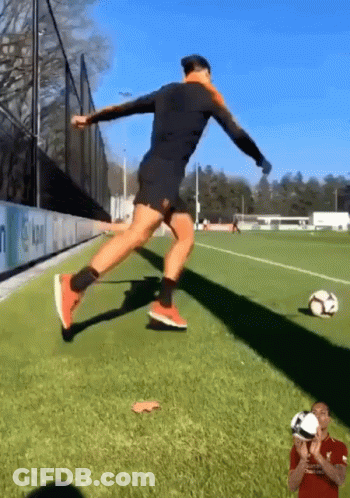 A Soccer Player Is Jumping In The Air To Kick A Ball GIF