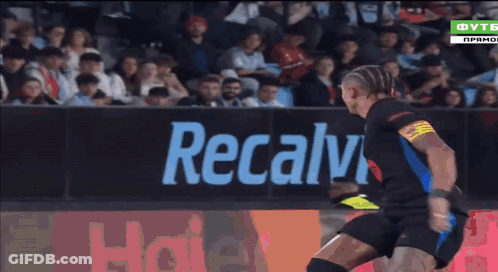 A Soccer Player Is Kicking A Ball In Front Of A Haier Sign GIF