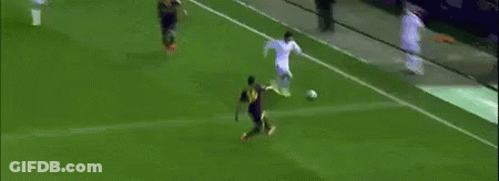 A Soccer Player Is Kicking A Ball Into The Goal While A Crowd Watches . GIF