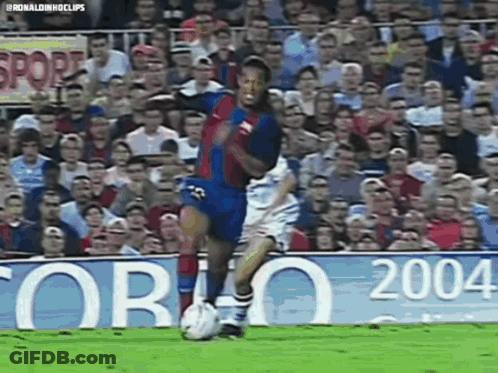 A Soccer Player Is Kicking A Soccer Ball In Front Of A Crowd Of People . GIF