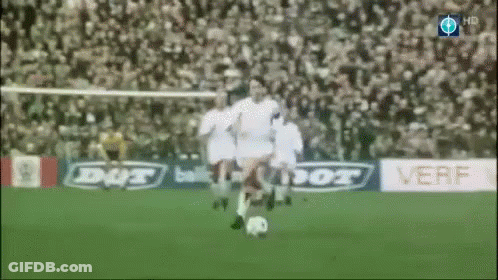 A Soccer Player Is Kicking A Soccer Ball On A Field With Ads For Dut And Verf In The Background GIF
