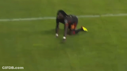 A Soccer Player Is Kneeling Down On The Field . GIF