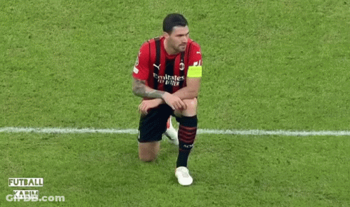 A Soccer Player Is Kneeling Down On The Field During A Match . GIF
