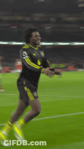 A Soccer Player Is Kneeling Down On The Field With A Banner Behind Him That Says ' Heineken ' GIF