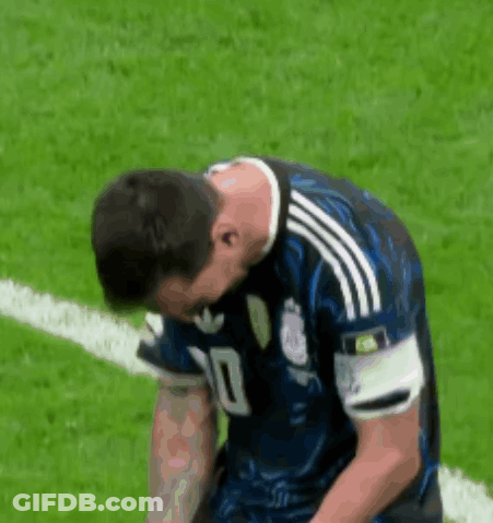 A Soccer Player Is Kneeling Down On The Field With His Head Down . GIF
