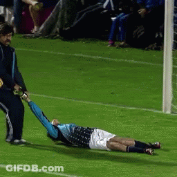 A Soccer Player Is Laying On The Field While Being Pulled By Another Player GIF