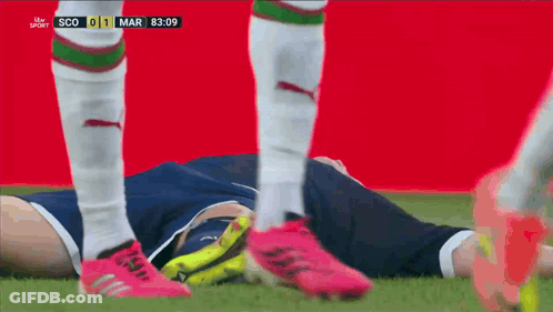 A Soccer Player Is Laying On The Ground During A Match Between Scotland And England GIF