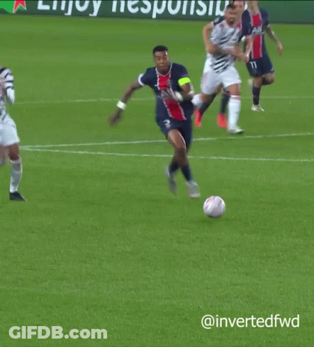 A Soccer Player Is Laying On The Ground While Another Player Is Jumping In The Air GIF