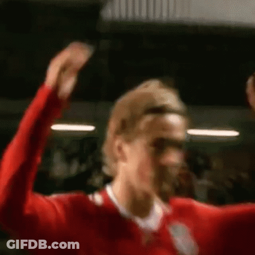 A Soccer Player Is Raising His Arms In The Air . GIF