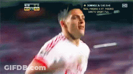A Soccer Player Is Running In Front Of A Tv Screen That Says Domingo On It GIF