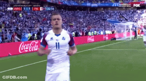A Soccer Player Is Running On The Field With A Coca Cola Ad Behind Him GIF
