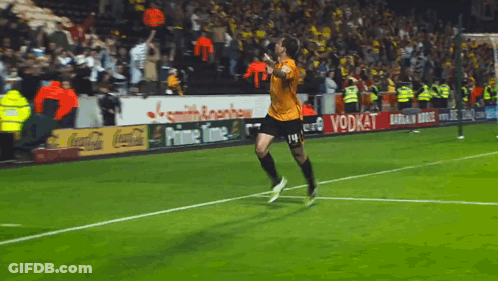 A Soccer Player Is Running On The Field With Ads For Coca Cola And Prime Time In The Background GIF