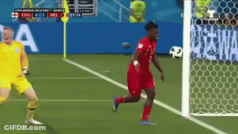 A Soccer Player Is Running Towards The Goal While A Goalie Stands Behind Him GIF