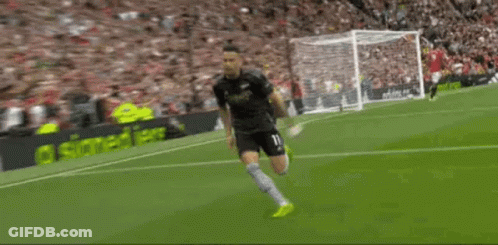 A Soccer Player Is Saluting The Crowd On The Field . GIF