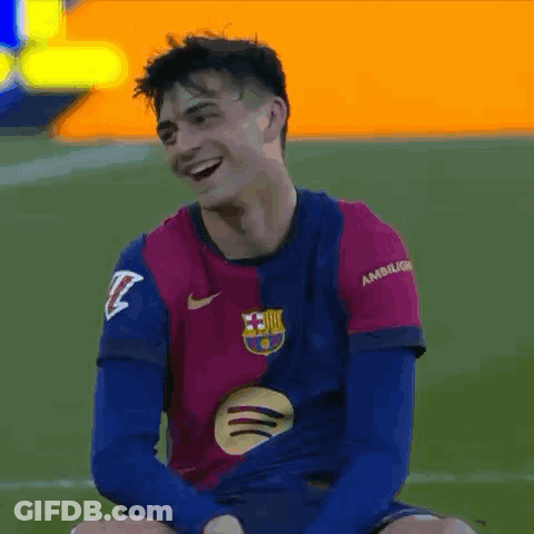A Soccer Player Is Sitting On The Field Laughing And Smiling . GIF