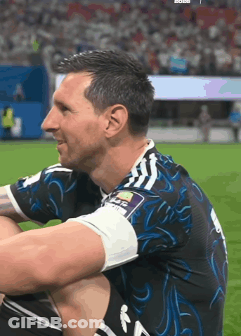 A Soccer Player Is Sitting On The Field Wearing A Blue And Black Jersey GIF