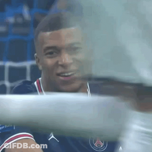 A Soccer Player Is Smiling And Looking At The Camera While Sitting On The Bench . GIF