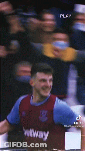 A Soccer Player Is Standing In Front Of A Crowd While Wearing A Purple And Blue Jersey . GIF