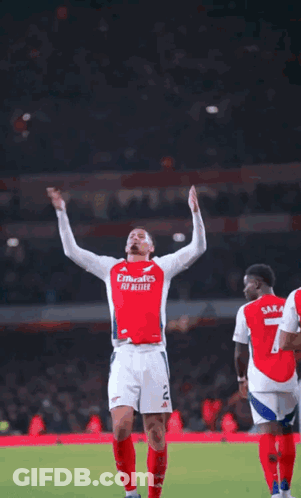 A Soccer Player Is Standing On A Field With His Arms Outstretched And Smiling . GIF