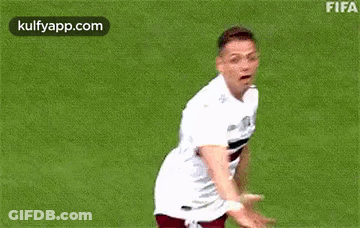 A Soccer Player Is Standing On A Field With His Arms Outstretched And Smiling . GIF