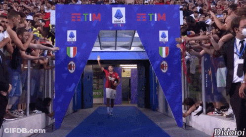 A Soccer Player Is Walking Through A Tunnel That Says Tim On It GIF
