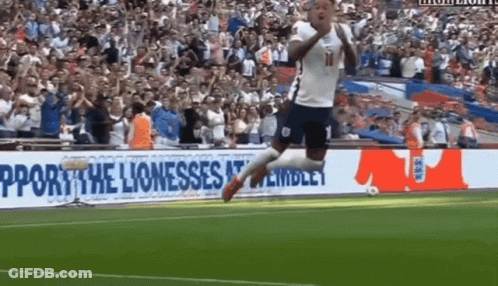 A Soccer Player Jumps In The Air In Front Of A Sign That Says Support The Lioness GIF