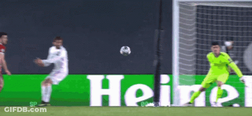 A Soccer Player Kicking A Ball In Front Of A Heineken Sign GIF