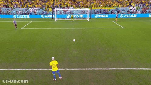 A Soccer Player Kicking A Ball In Front Of A Wanda Advertisement GIF