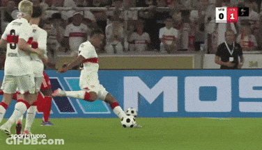 A Soccer Player Kicking A Soccer Ball In Front Of A Mos Sign GIF