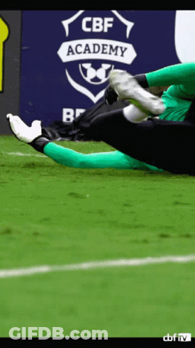 A Soccer Player Kicks A Ball In Front Of A Cbf Academy Sign GIF