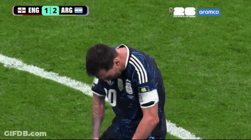 A Soccer Player Kneeling Down On The Field With A Scoreboard Behind Him That Says Aramco GIF
