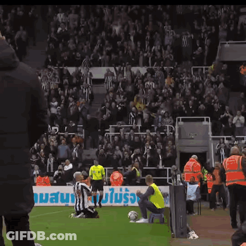 A Soccer Player Kneels On The Field In Front Of A Banner That Says ' Allianz ' GIF