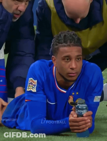 A Soccer Player Laying On The Grass With A Can Of Powerade In His Hand GIF