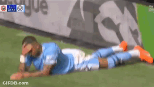 A Soccer Player Laying On The Ground With His Head In His Hands GIF