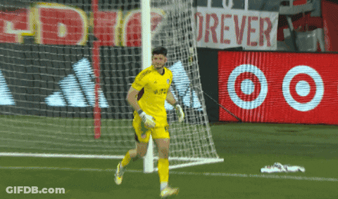 A Soccer Player Runs Towards A Goal With A Sign That Says Forever In The Background GIF
