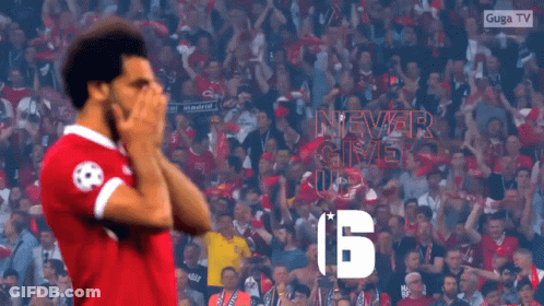 A Soccer Player Stands In Front Of A Crowd With A Sign That Says Never Give Up GIF