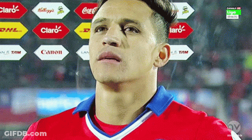 A Soccer Player Stands In Front Of A Display Of Logos For Claro And Canon GIF