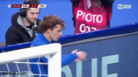 A Soccer Player Stands In Front Of A Sign That Says Photo On It GIF