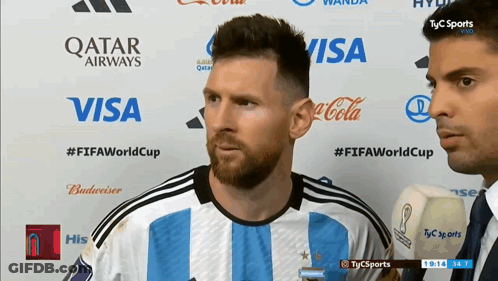 A Soccer Player Stands In Front Of A Wall That Says Qatar Airways Visa Coca Cola And Budweiser GIF