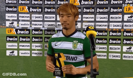 A Soccer Player Stands In Front Of A Wall With Bwin Advertisements GIF