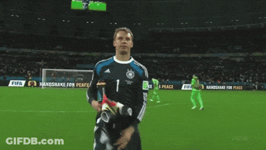 A Soccer Player Stands On A Field With A Sign That Says Handshake For Peace GIF