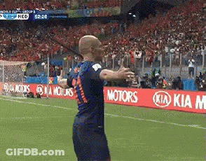 A Soccer Player Stands On A Field With Kia Motors Signs In The Background GIF